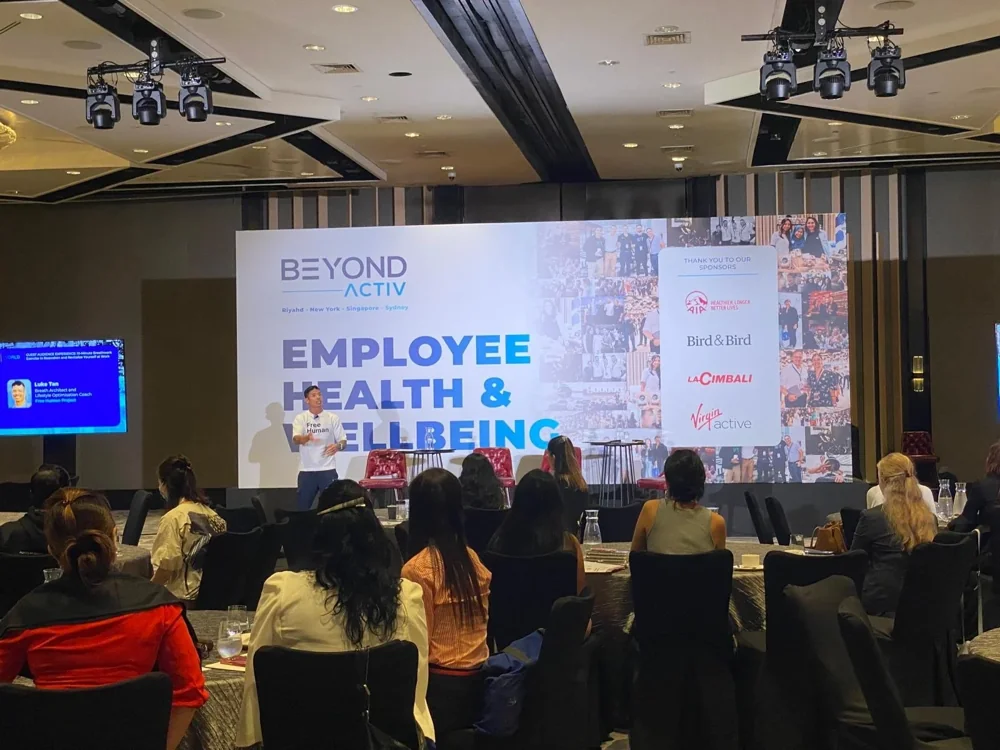 Luke presenting on stage at Beyond Activ's Employee Health and Wellbeing event