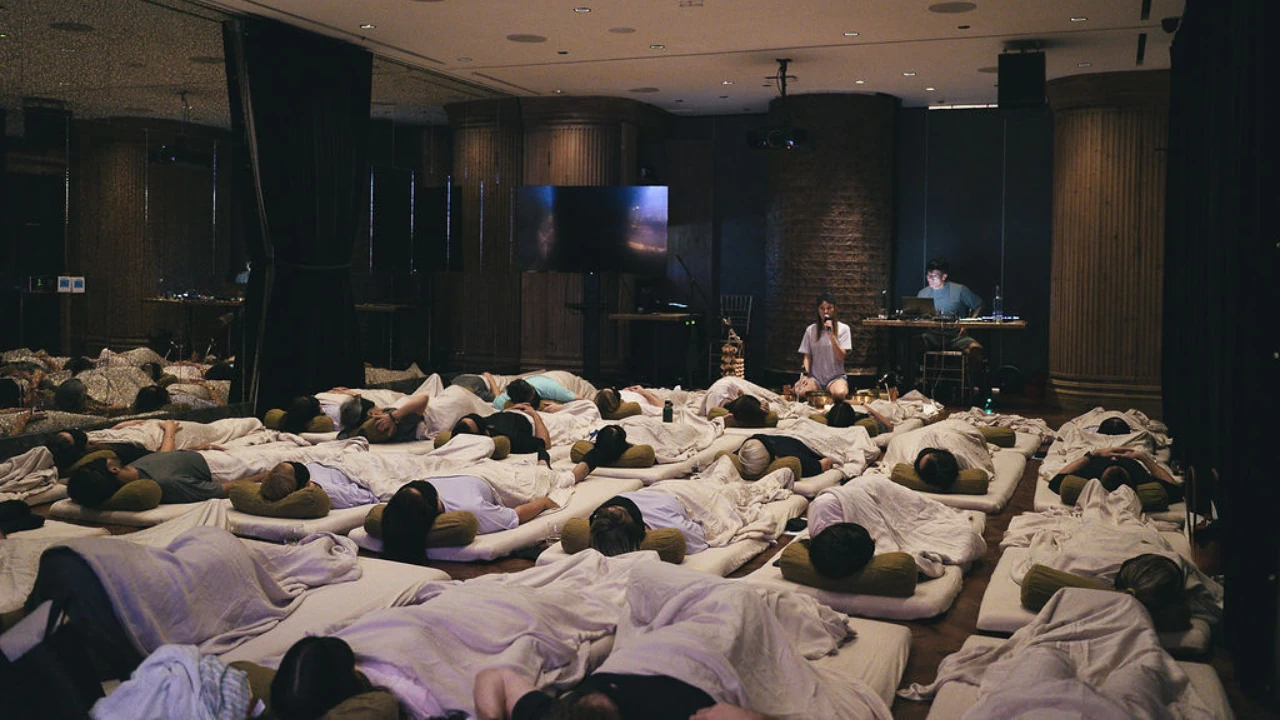 Participants resting on mats as Candice guides a sound experience and Luke provides the soundscape