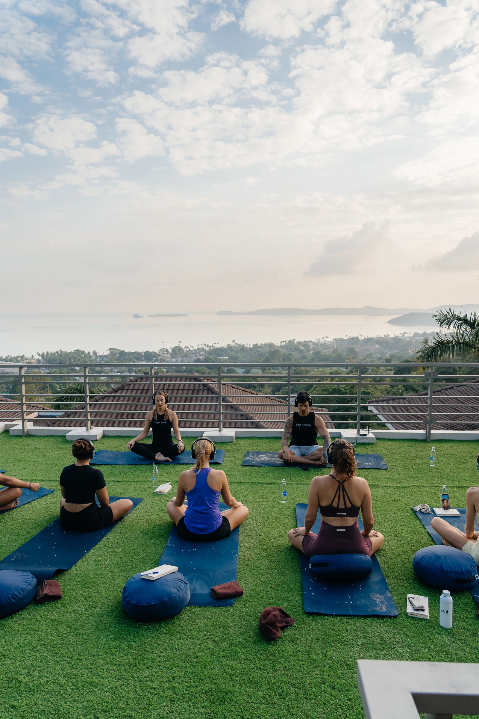 Luke and Candice guiding a seated group experience on a terrace overlooking the sea